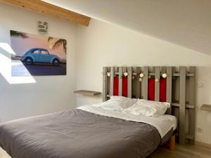 a bedroom with a bed and a painting of a car at T3 Sur les Toits de Propriano in Propriano