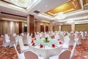 une salle de conférence avec des tables, des chaises et des lustres blancs dans l'établissement Holiday Inn Shanghai Pudong Nanpu, an IHG Hotel, à Shanghai
