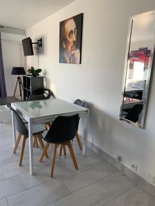 a table and chairs in a room with a mirror at studio avec terrasse parking in Six-Fours-les-Plages