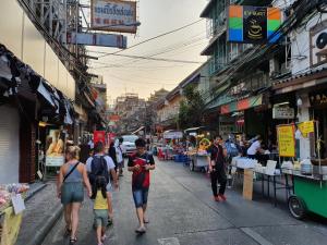 eine Gruppe von Menschen, die eine Stadtstraße entlanggehen in der Unterkunft The Studio at Sathorn Terrace in Bangkok