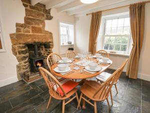 a dining room with a table and a fireplace at Springfield Cottage in Whitby