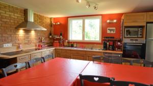 a kitchen with a red table in the middle at Rêve d'Etretat in Bordeaux-Saint-Clair