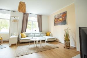 uma sala de estar com um sofá e uma mesa em FULL HOUSE Premium Apartments - Halle Südstadt em Halle an der Saale