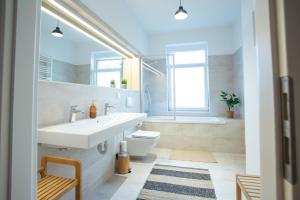 een badkamer met een wastafel, een toilet en een bad bij FULL HOUSE Premium Apartments - Halle Südstadt in Halle an der Saale