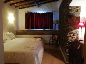 ein Schlafzimmer mit einem Bett und einem roten Vorhang in der Unterkunft Solar da Cavalariça in Ourique