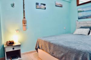 a bedroom with a bed and a table with a lamp at Shanti, La Casa Azul in Palm-Mar