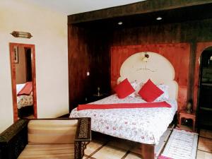 een slaapkamer met een bed met rode kussens erop bij Riad Al Zahia in Essaouira