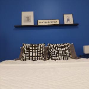 two pillows sitting on a bed with a blue wall at COCO Guesthouse in Madaba