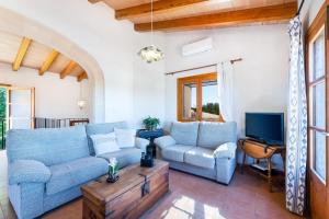 a living room with a blue couch and a tv at Villa Son Allarga in Costitx