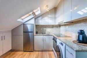 a kitchen with white cabinets and a stainless steel refrigerator at Imperial apartment 1, 2 e 3 in Braga