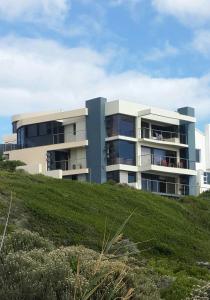 a building on top of a grassy hill at Royal Albatros in Gansbaai