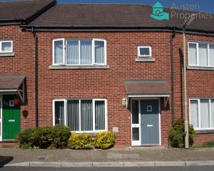 a red brick house with a green door and windows at Modern 2 Bed House Walking Distance to Hospital in Sherborne Saint John