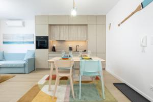 a kitchen with a table and two chairs at JANTAR APARTAMENTY Posesja Kapitańska20A-28 in Grzybowo