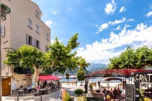 een groep mensen die aan tafels buiten een gebouw zitten bij Casa Nostra : bienvenue chez nous ! in Saint-Florent