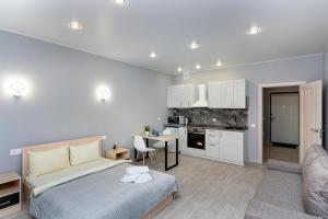 a bedroom with a bed and a living room at Апартаменты Central Park на Таврической 9к1 in Tyumen