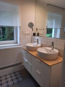 a bathroom with two sinks and a mirror at Precioso apartamento, aparcamiento gratis in Augustusburg