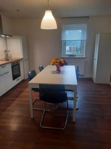 a kitchen with a table with a vase of flowers on it at Precioso apartamento, aparcamiento gratis in Augustusburg