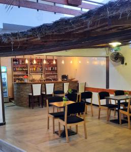尼亚加乐查玛玛酒店 的有桌椅和酒吧的餐厅