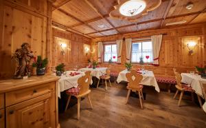 un restaurante con mesas y sillas en una habitación en Hotel Hasenauer, en Saalbach Hinterglemm