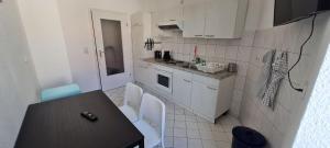 a kitchen with white cabinets and a table and chairs at Cozy 2 room flat with WLAN in Magdeburg