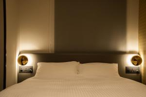 una camera con un letto bianco con due luci di GRIDS PREMIUM HOTEL OSAKA NAMBA ad Osaka