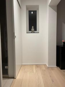 a room with a white wall with a window and a wooden floor at Ammersee Haus in Haus,wunderschöne Designerferienwohung mit Garten in Dießen am Ammersee