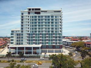 un edificio blanco alto con una calle delante en Stirling Suites Hotel & Serviced Apartment, en Miri