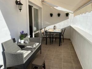 Un balcón con sillas, una mesa y una mesa con sillas. en Bahia De Casares, en Estepona