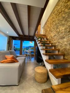 een woonkamer met een trap met een stenen muur bij Casa Rural Los Abuelos in Piloña