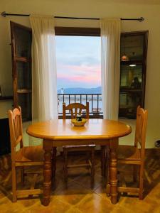 a wooden table and chairs with a view of the ocean at Apartamento Los Laureles in Laroles