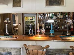 a bar with a counter with a lot of alcohol at The Coach House Inn in Oakham