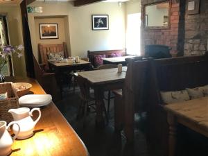 een restaurant met tafels en stoelen en een bakstenen muur bij The Coach House Inn in Oakham