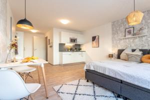 a bedroom with a bed and a desk and a kitchen at NEU☆Business Apartment☆Messe/Airport☆Tiefgarage in Leinfelden-Echterdingen