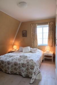 - une chambre avec un lit, deux lampes et une fenêtre dans l'établissement Villa Näs - a modern country villa, à Mullsjö