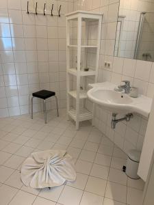 ein weißes Badezimmer mit einem Waschbecken und einem Spiegel in der Unterkunft Jasmin in Schladming