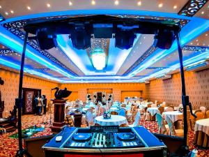 a large banquet hall with white tables and chairs at Hotel Eden Garden in Sigiriya