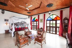 a room with a bed and chairs and stained glass windows at Tembo House Hotel in Zanzibar City