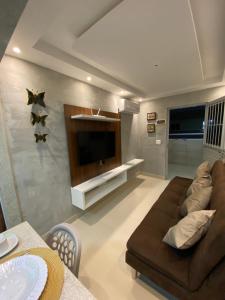uma sala de estar com um sofá castanho e uma televisão de ecrã plano em Condomínio manguezal em Porto de Galinhas