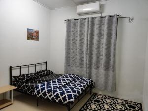 a bedroom with a bed and a curtain at LEBOK HOMESTAY AIRPORT KUANTAN in Kuantan