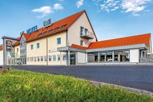 a large white building with an orange roof at Hotel sleep & go in Bad Hersfeld