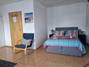 a bedroom with a bed and a chair at Haus Charlotte auf Sylt, strandnah in Westerland