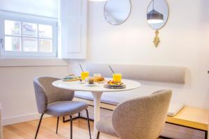 een kleine witte tafel met stoelen en drankjes erop bij Santa Luzia Apartments By Guestify in Guimarães
