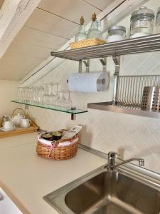 a kitchen with a sink and a counter with glasses at Apartment The Rock in Brienno