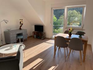Una sala de estar con una mesa y sillas y una ventana. en Ferienwohnung „Zur alten Brauerei“, en Mesenich