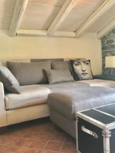 a couch in a living room with a stone wall at Apartment The Rock in Brienno