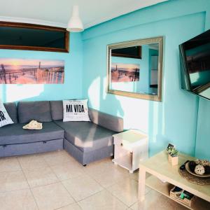 a living room with a couch and a tv at Shanti, La Casa Azul in Palm-Mar