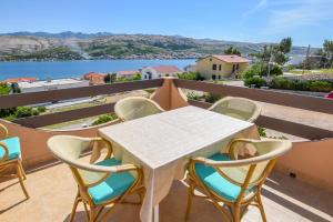 ein weißer Tisch und Stühle auf einem Balkon mit Aussicht in der Unterkunft Apartments Marija in Pag