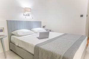 a bedroom with a large bed with a laptop on it at Arinnanda Hotel Cesme in Çeşme