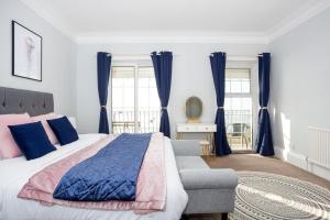 a bedroom with a bed and a chair and windows at Compass Point by Sorted Stay in Southend-on-Sea