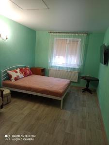 um quarto verde com uma cama e uma janela em Нова квартира em Poltava